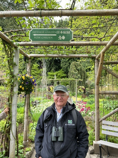 Dr. Gary Rankin stands beneath the entrance to a rose garden during one of the couple's horticultural travels.